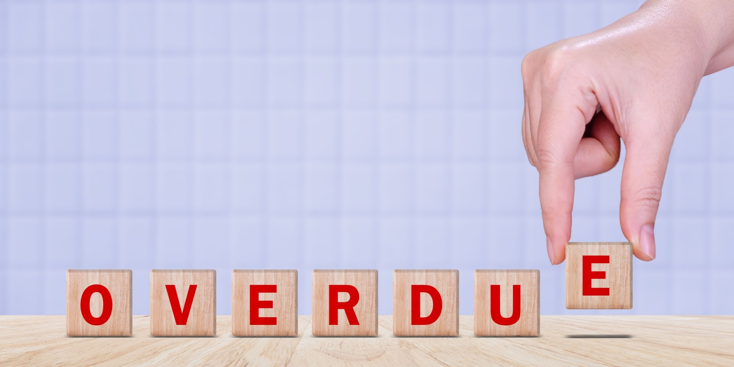 The word OVERDUE made with wood building blocks.