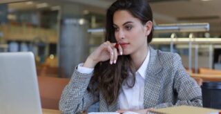 Portrait of a pretty female company secretary with laptop in office.